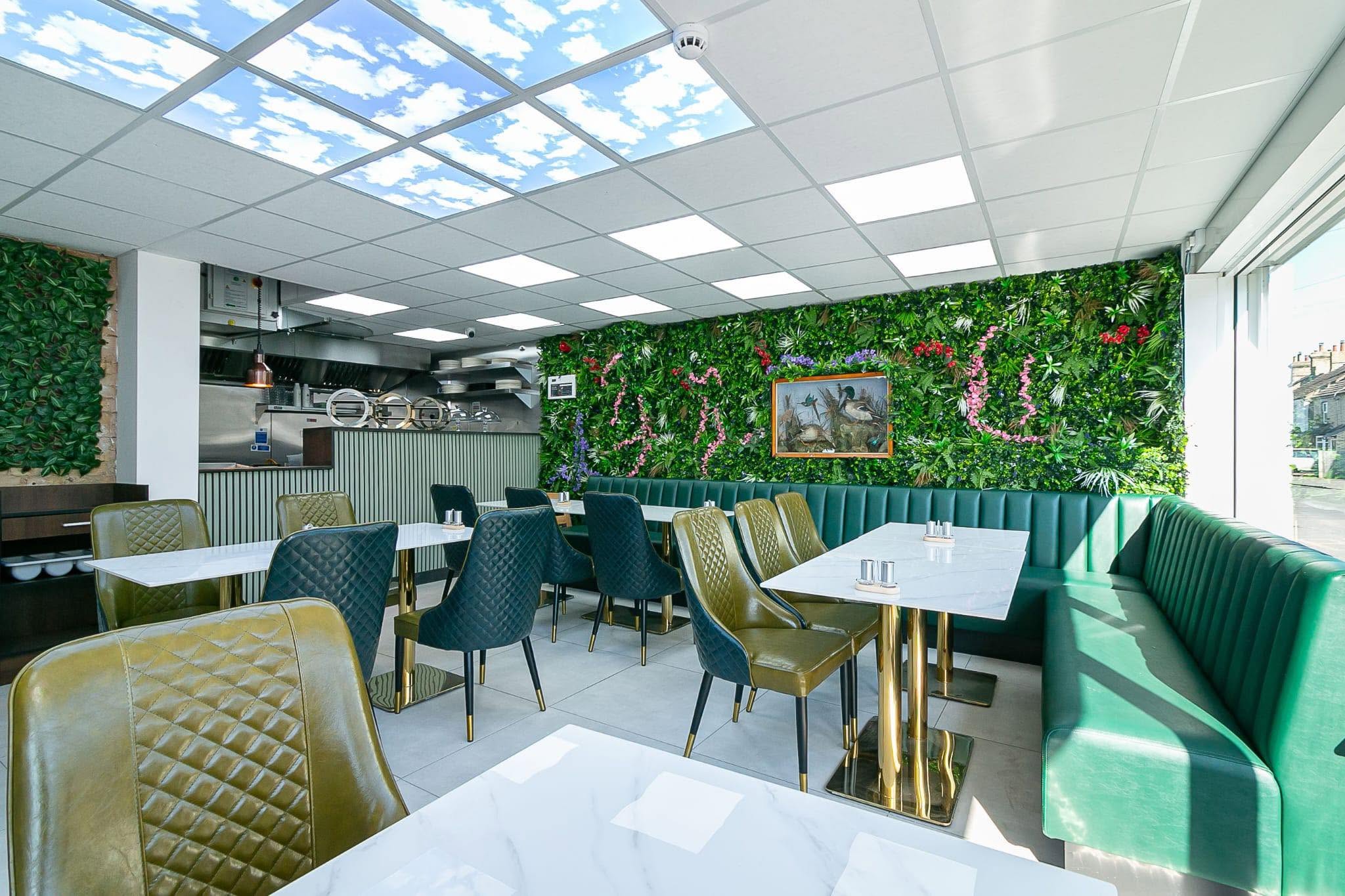 Bites & Breeze interior – lush green walls and cosy seating